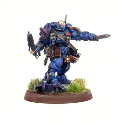 Błękitny Space Marine z mieczem i toporem, gotowy do walki. To zdjęcie na studia, ukazujące szczegóły figurki.