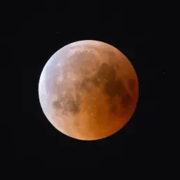 Czerwony Księżyc w pełni na czarnym tle. Dowiedz się, jak zrobić zdjęcie księżyca iPhonem, by uchwycić takie detale.
