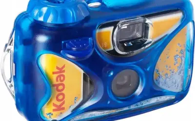 Niebieski aparat jednorazowy Kodak z widocznym filmem. Dowiedz się, jak wywołać zdjęcia z aparatu jednorazowego, aby zachować wspomnienia.
