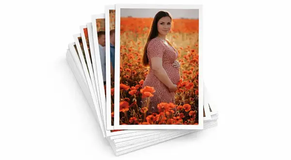 Stos zdjęć formatu 13x18, na wierzchu ciężarna kobieta w sukience wśród maków.