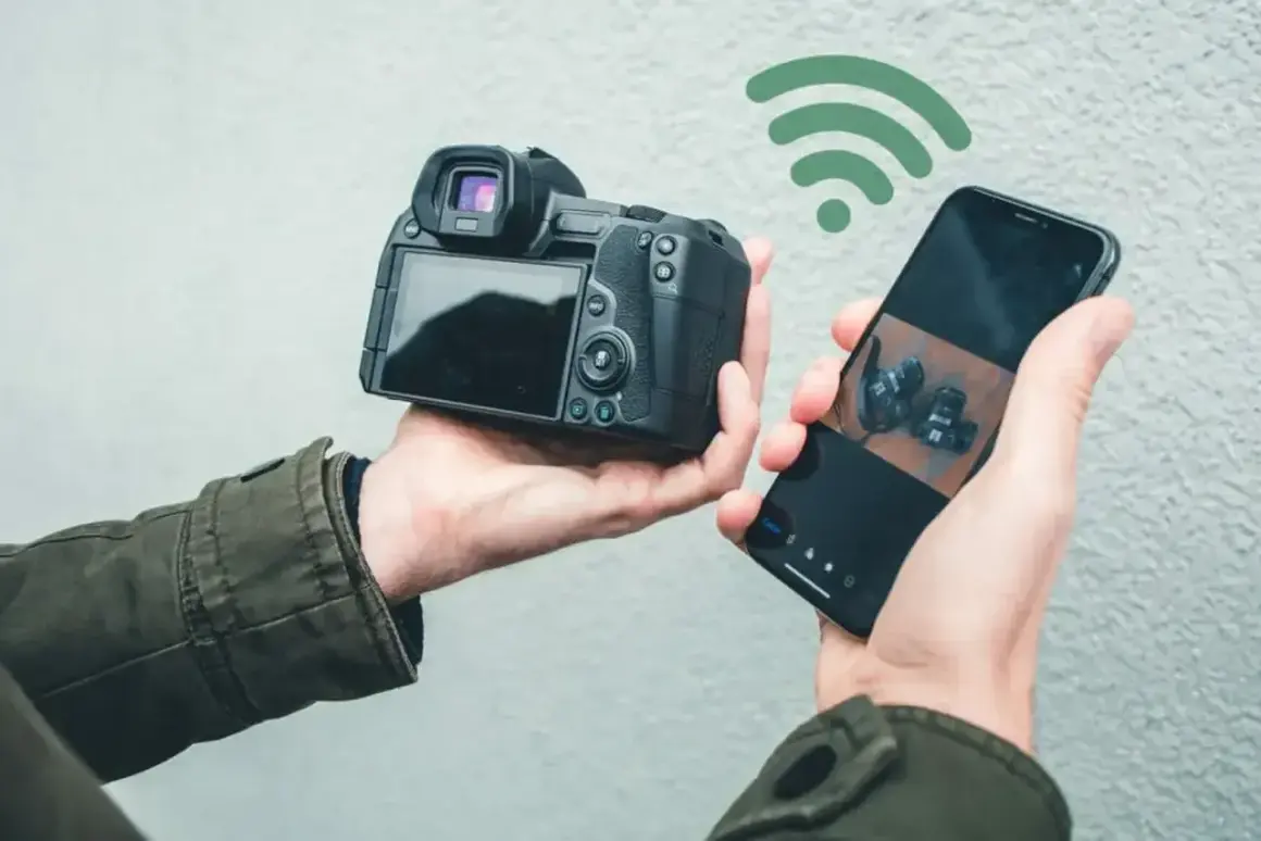 Bezprzewodowe przesyłanie zdjęć z aparatu do telefonu za pomocą SnapBridge po polsku. Widok z tyłu aparatu i ekran telefonu z podglądem.